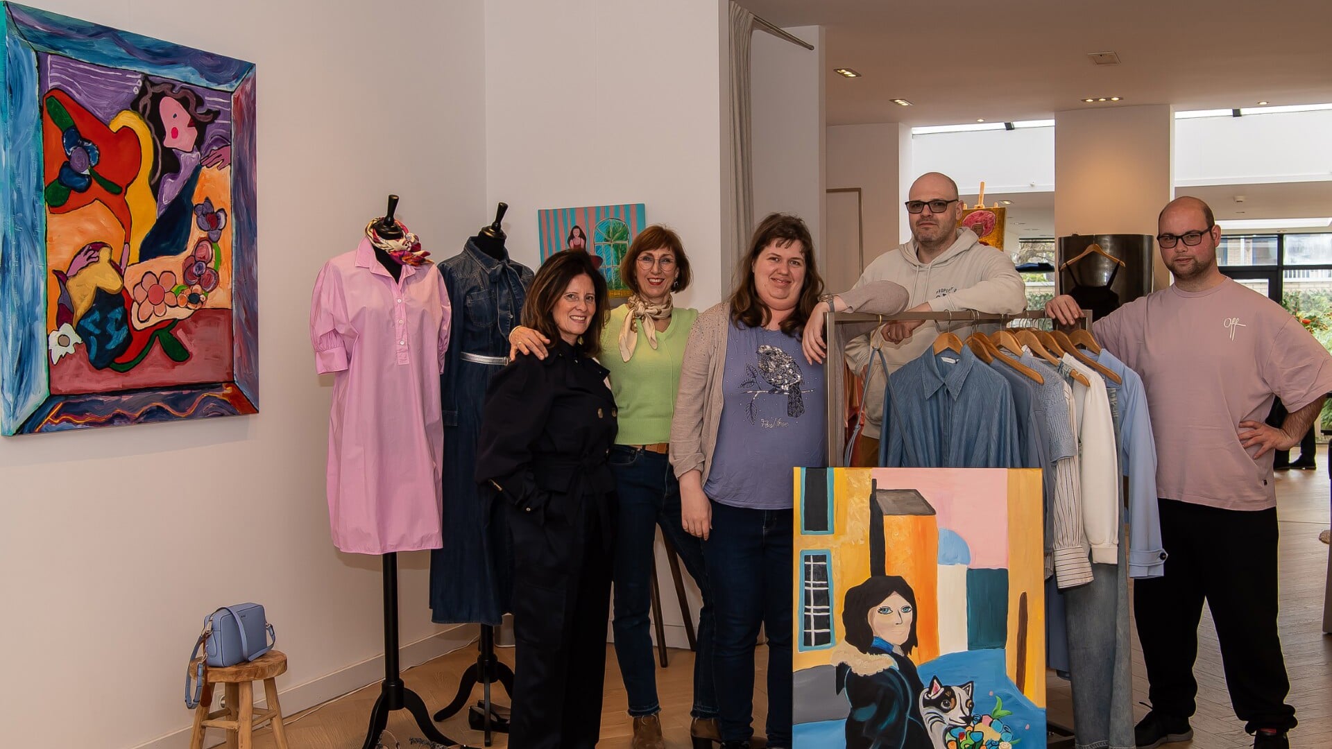 Kleurrijke mode en dito kunst gaan samen bij HERMEE. Van links naar rechts: Peggy van der Heijden, Anneke Goede (organisator van de expositie), Stéphanie, begeleider Raymond Huizinga en Kevin. 