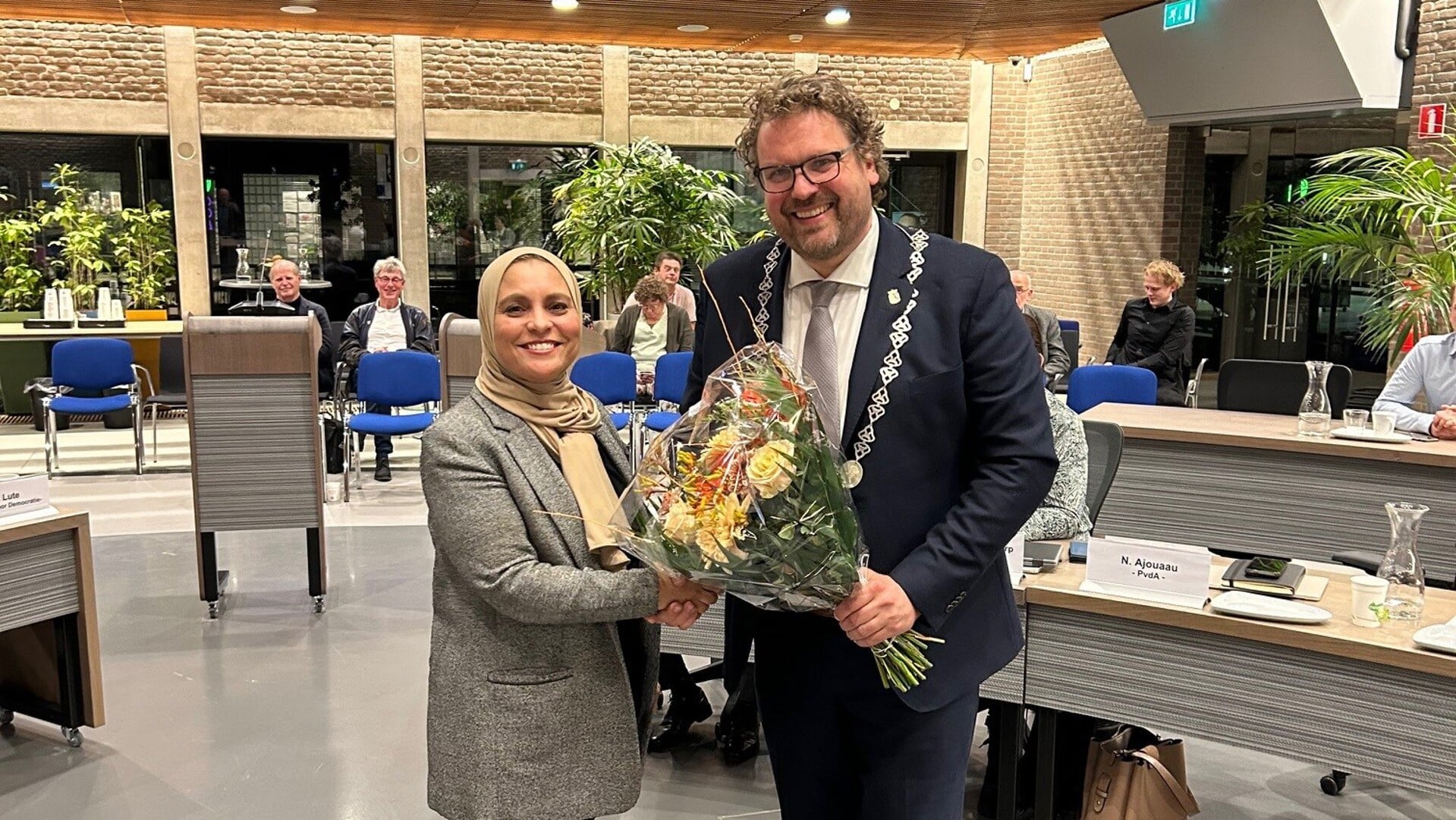 Bloemen voor vertrekkend raadslid Naïma Ajouaau, uit handen van burgemeester Maarten Poorter van Dijk en Waard.