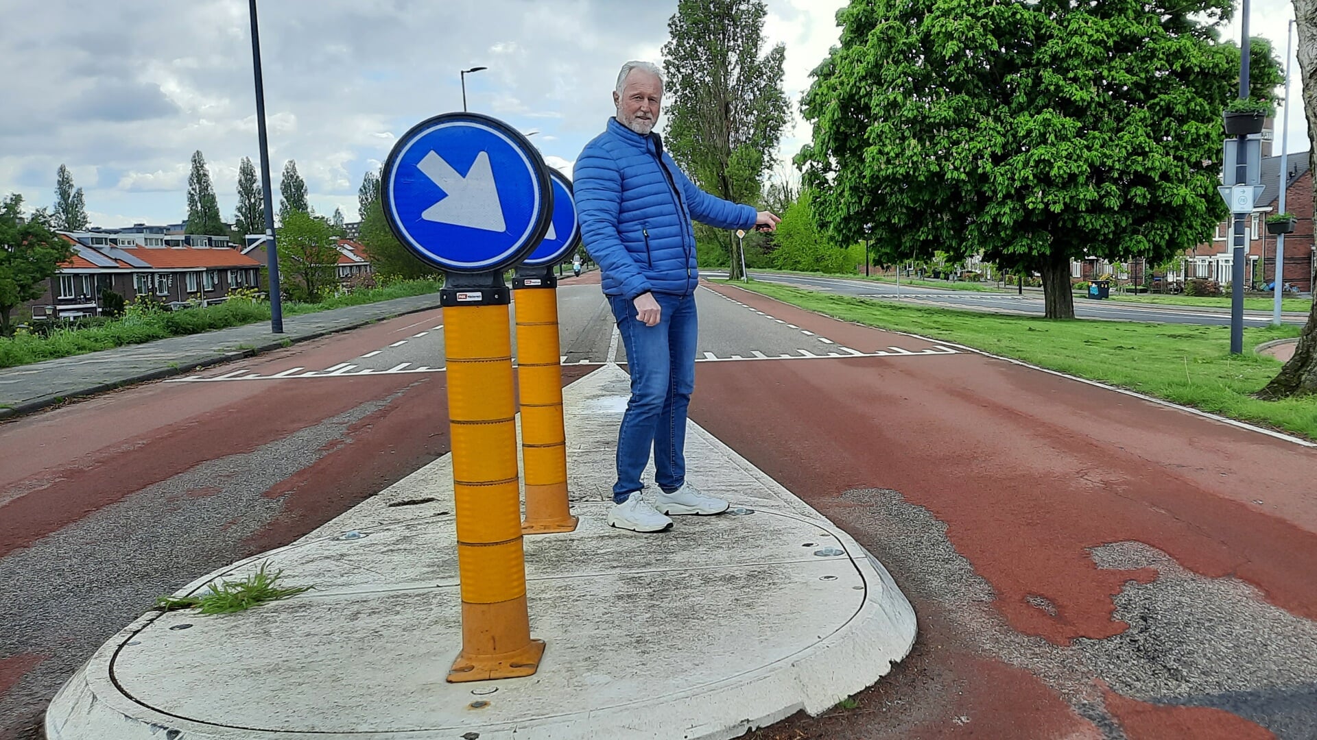 Gemeenteraadslid Marco van Unen wijst naar het ontbreken van de belijning naast de aangebrachte middeneilanden, wat voor een onveilige verkeerssituatie zorgt voor fietsers.