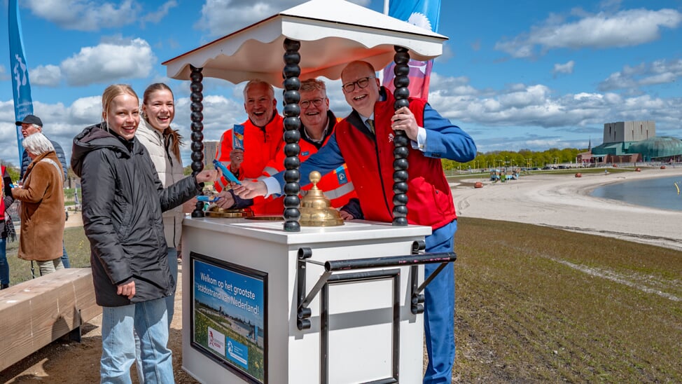 De eerste bezoekers van het grootste stadsstrand van Nederland krijgen een ijsje uitgereikt van alliantiemanager Kees Uiterwijk Winkel, hoogheemraad Arnold Langeveld en wethouder Arthur Helling. 