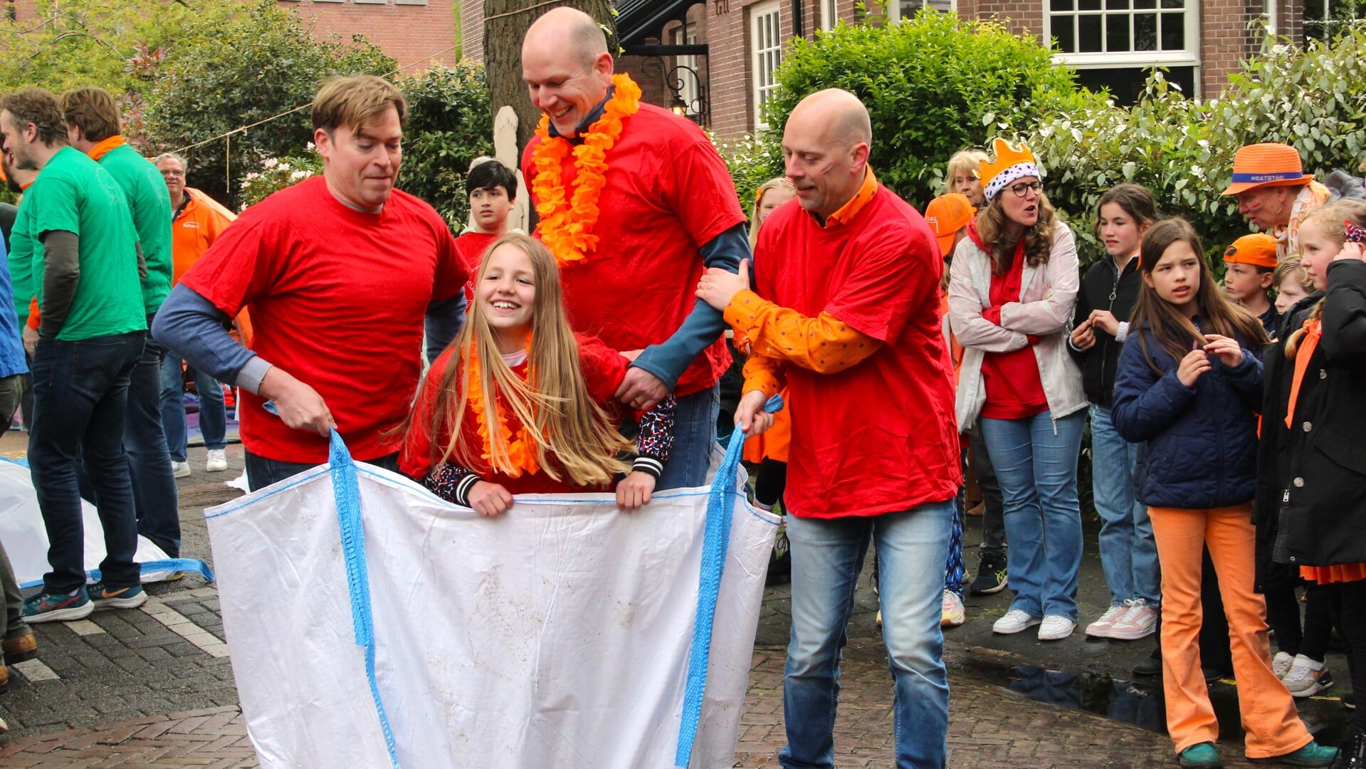 Lauren en drie grote, sterke mannen tijdens de mega zakloopwedstrijd in Leeuwendaal.