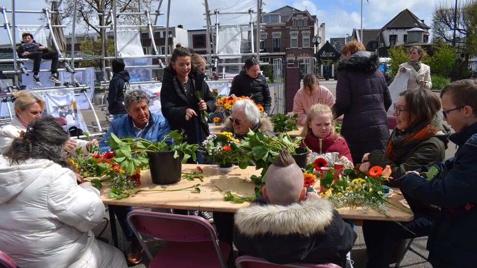 Jong en oud aan het bloemschikken.