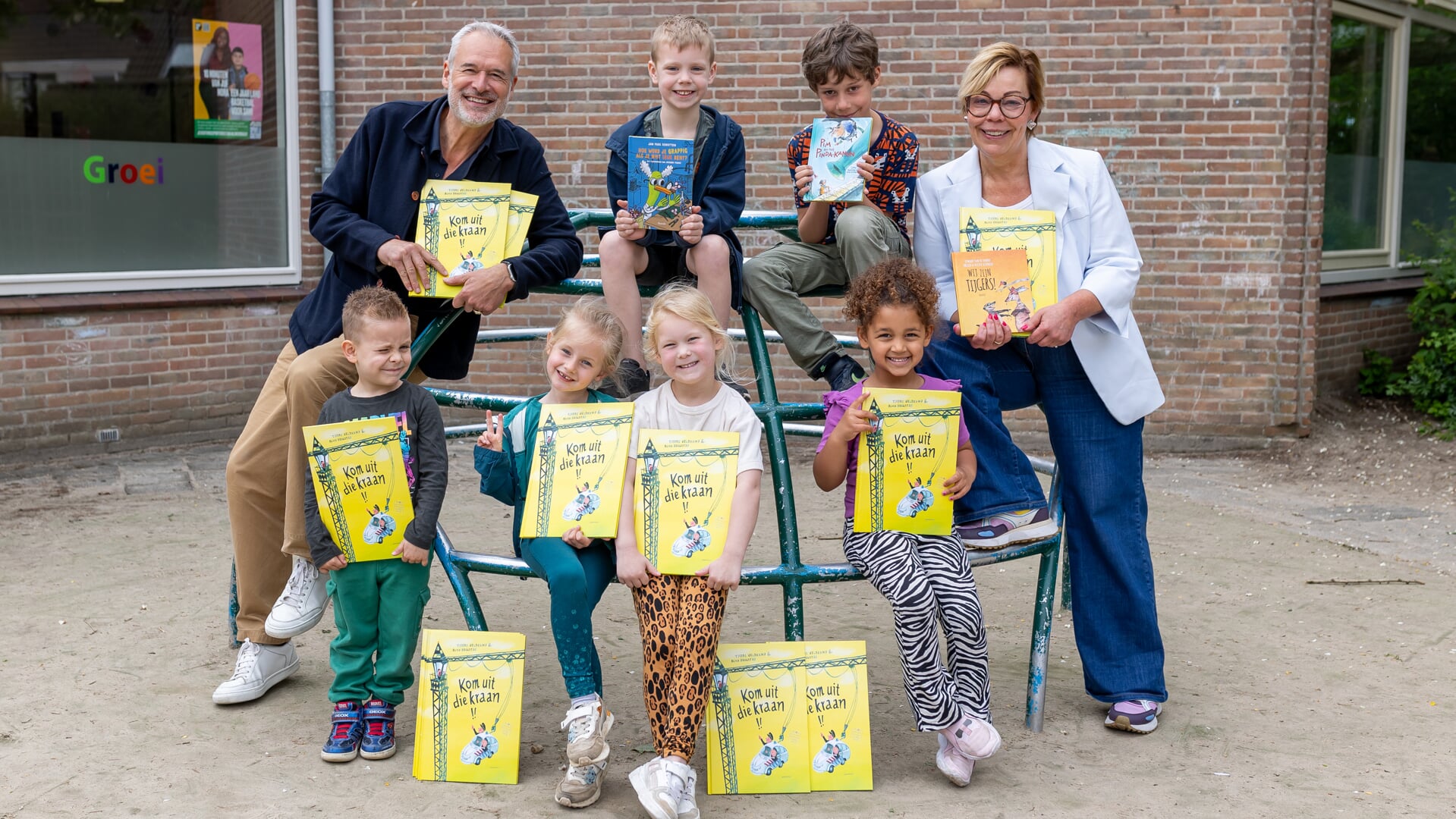 Wethouder Natalie Saaf reikt samen met Henk Schulte van Boekhandel Het Leesteken boeken uit aan leerlingen van Basisschool Trifolium in Purmerend.  