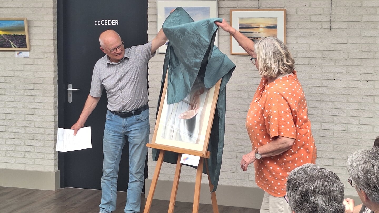 De onthulling van het schilderij Welcome van Karen Stolk, door voorzitters Peter Verbeek (Aquarellisten Kring Westland) en Corinne Mostert (Kunst Vocaal).