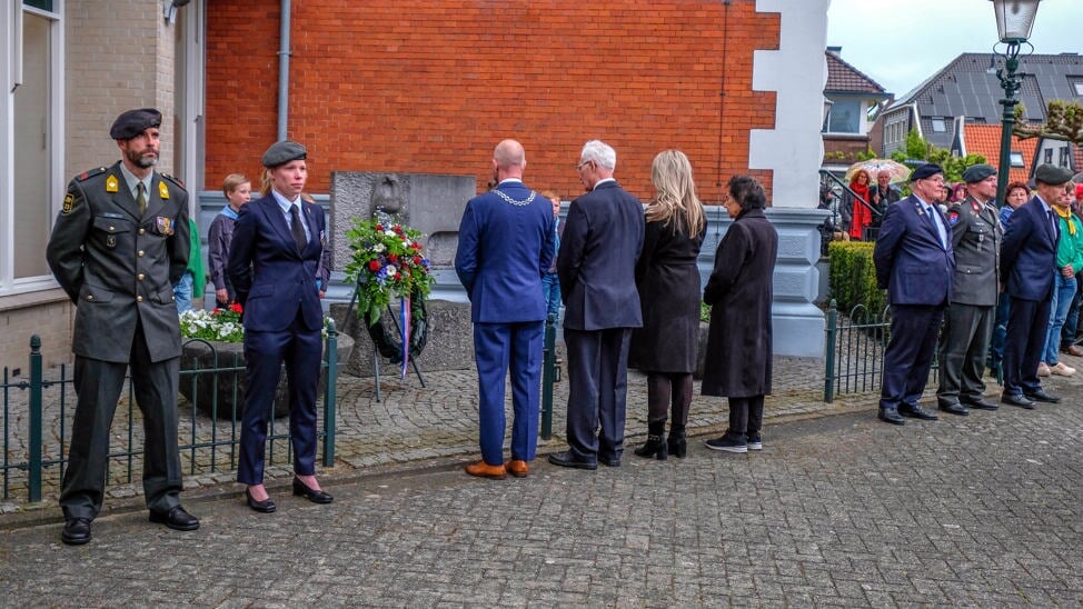 Onder meer burgemeester Nieuwland ziet hoe heel veel mensen, nabestaanden en mensen uit Uitgeest bloemen leggen bij het monument. 