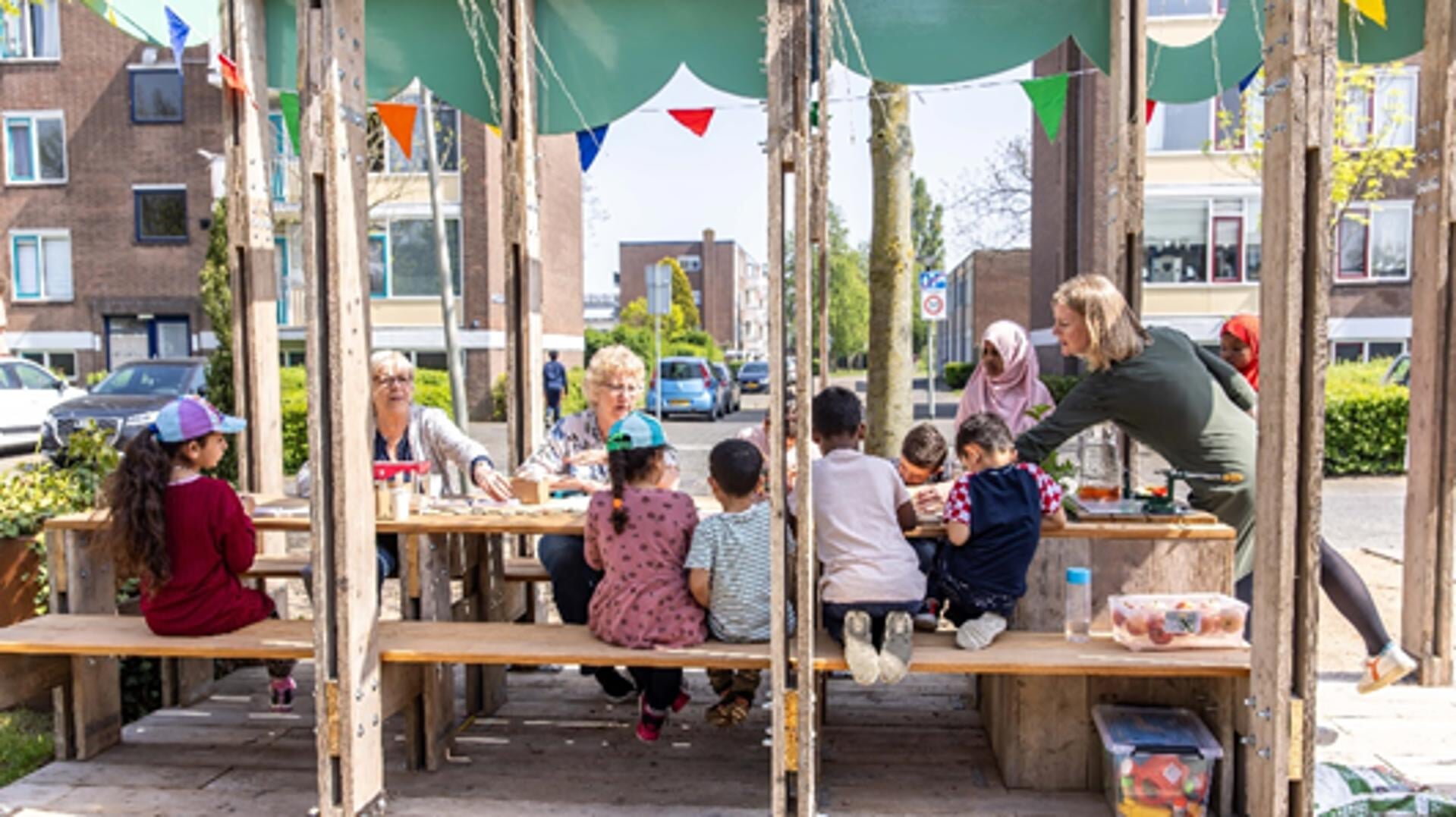 Bewoners en kinderen in de Vlaardingse Zuidbuurt zijn creatief bezig aan de buurttafels in de geplaatste parklet in hun buurt.