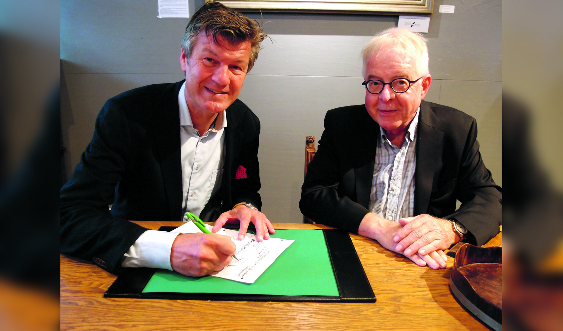 Burgemeester Mans en Peter Sibinga ondertekenen de ingebruikgeving van het antieke raadsmeubilair.(foto Hans Boot)