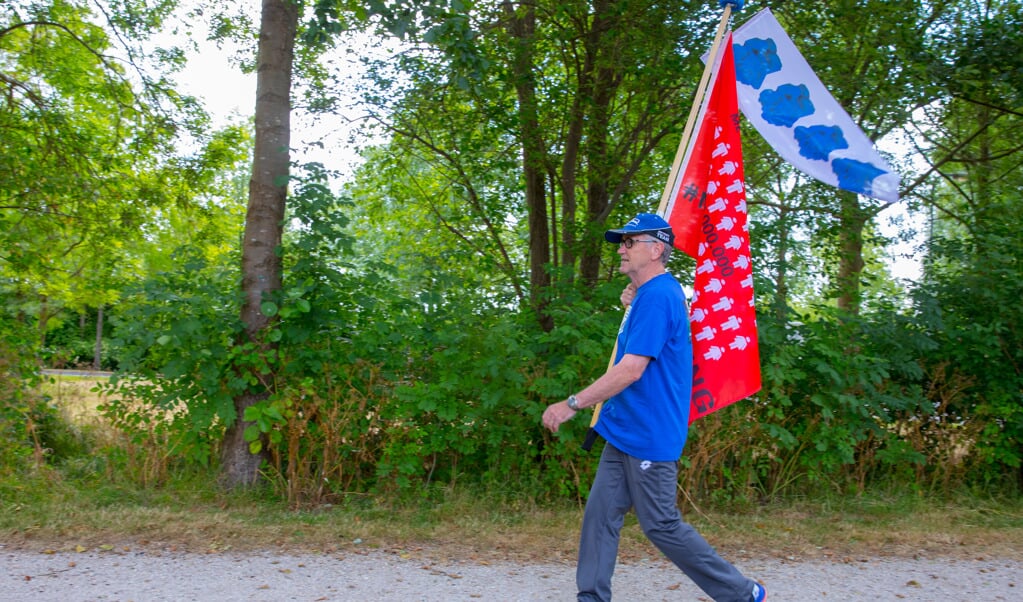 René Robert loopt tijdens de Nijmeegse Vierdaagse mét de Millions Missing-vlag: "Ik wil zoveel mogelijk aandacht vragen en geld ophalen voor de ziekte ME." (Foto: Vincent de Vries/RM)