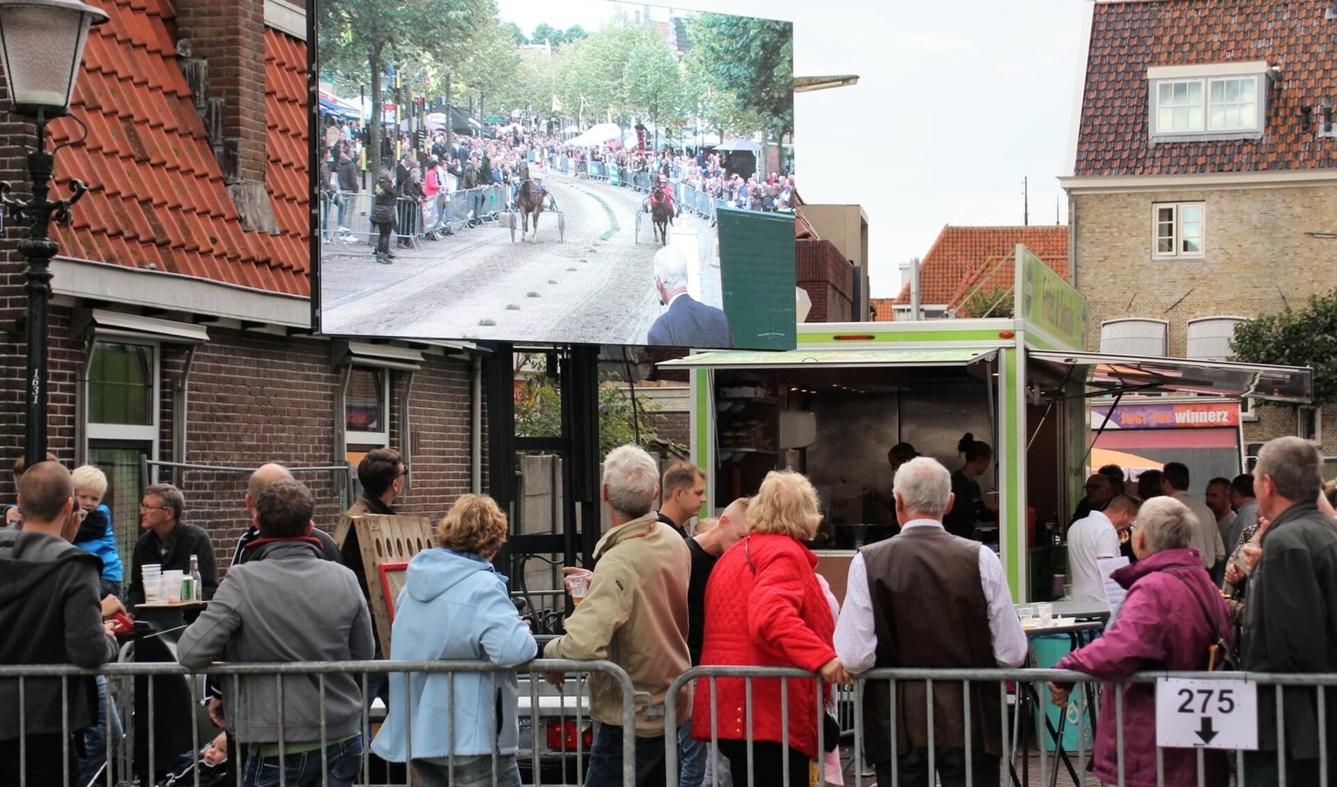 Bezoekers van de harddraverij in Medemblik volgen de hele koers live en op scherm. (Foto: aangeleverd)