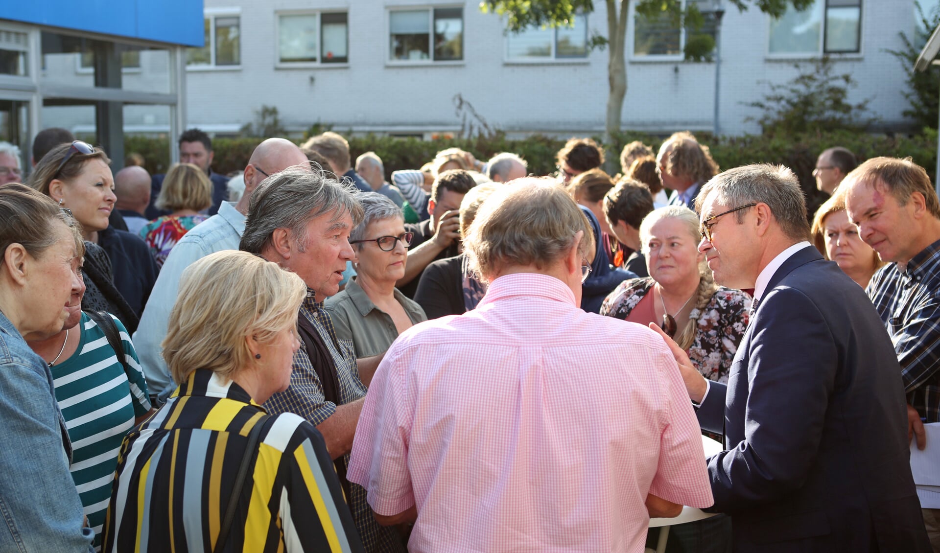 Burgemeester Jos Wienen is druk in gesprek met bewoners uit Haarlem-Oost die naar het open spreekuur zijn gekomen. (Foto: Rowin van Diest)