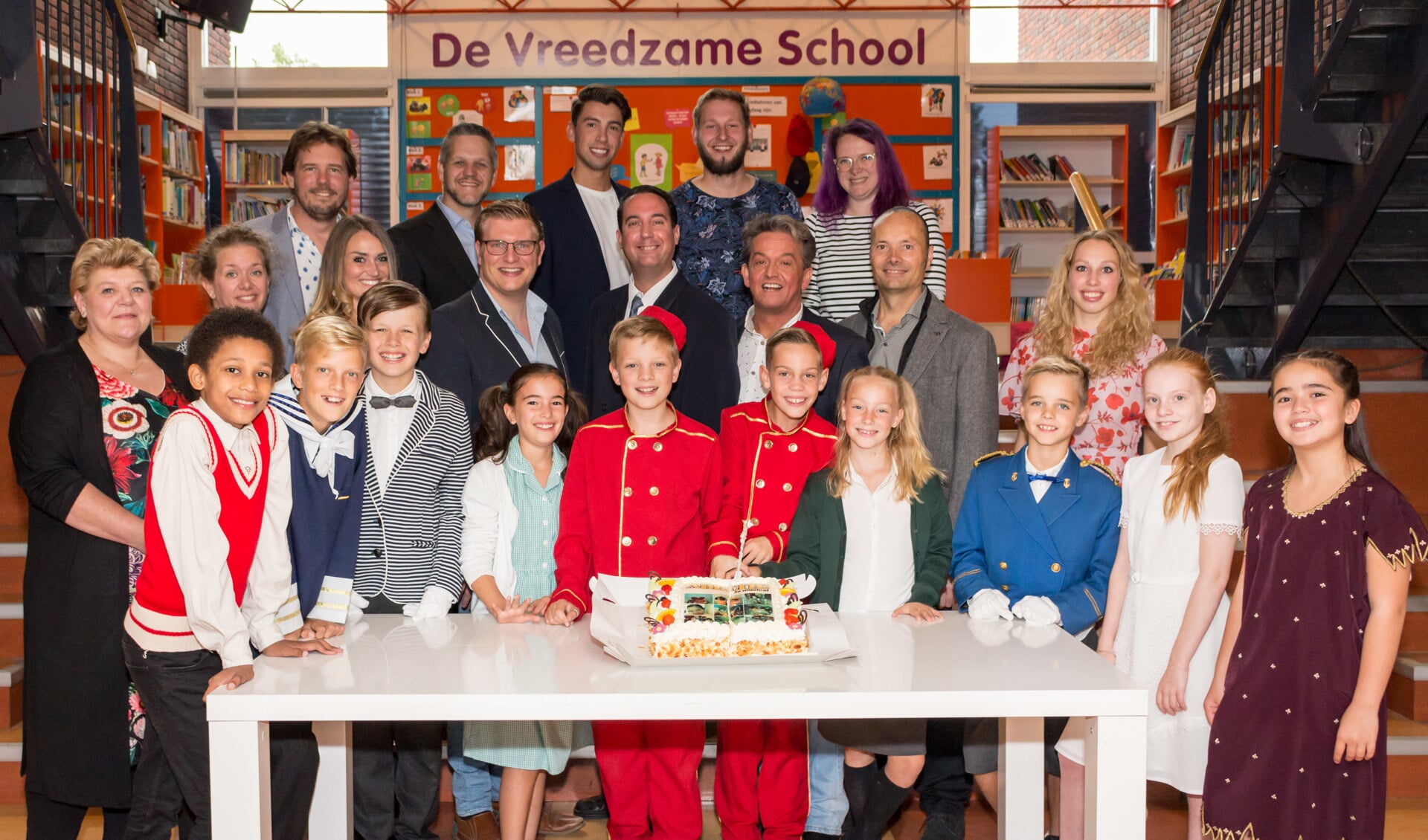 De volwassen- en een deel van de kindercast van Kids with Attitude snijden de taart aan van 'Abeltje de Musical'. (foto AvdK Fotografie)