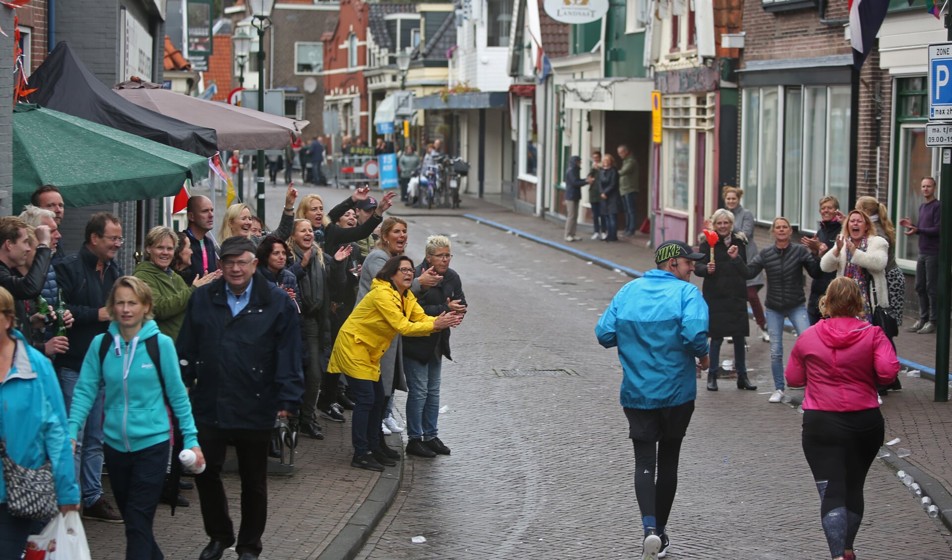 Toeschouwers moedigen achterhoede Damlopers aan op de Peperstraat in Zaandam. (Foto: Rowin van Diest)