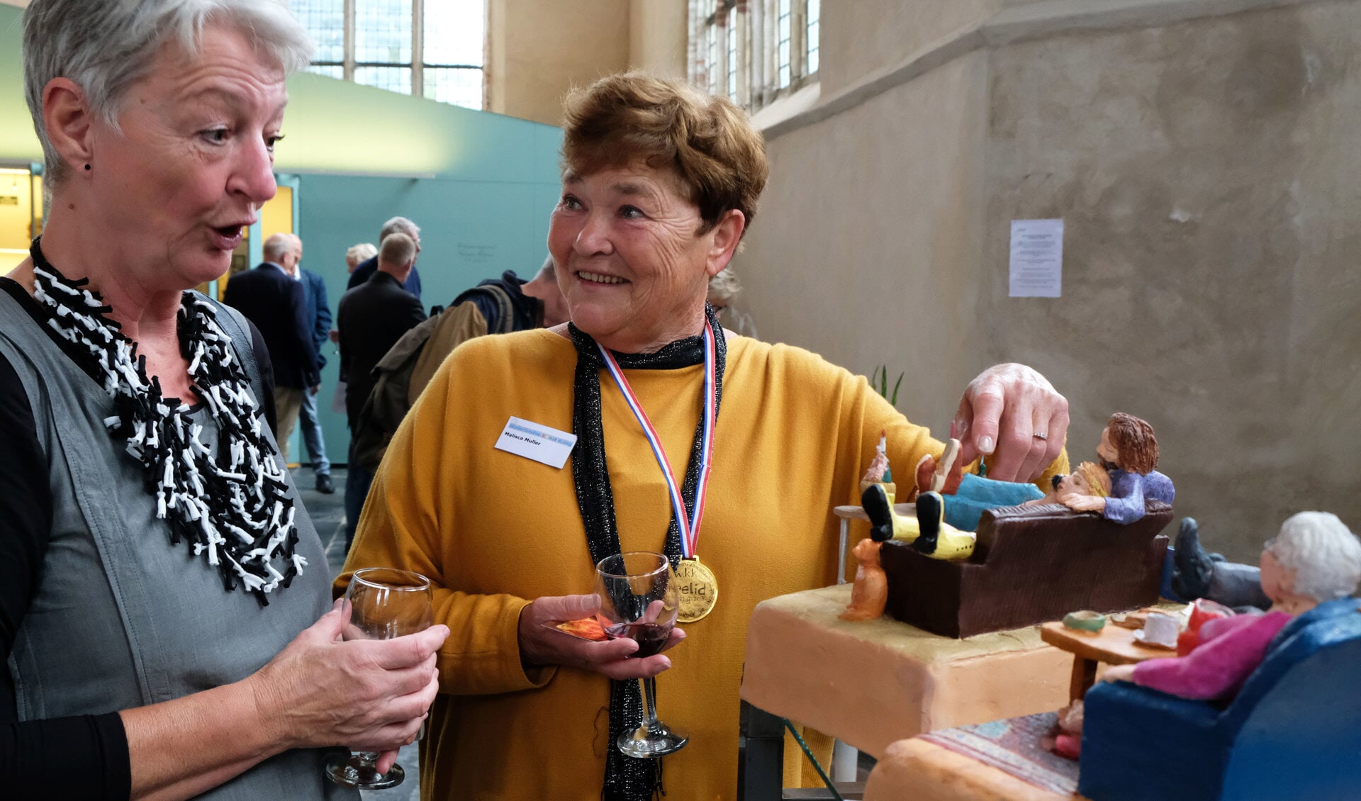 Voorzitter van de Waterlandse Kunstkring Vera Schoone (links) met erelid Malisca Muller (rechts) bij werk van Malisca. (Foto: Ria Houweling/Bouwman)