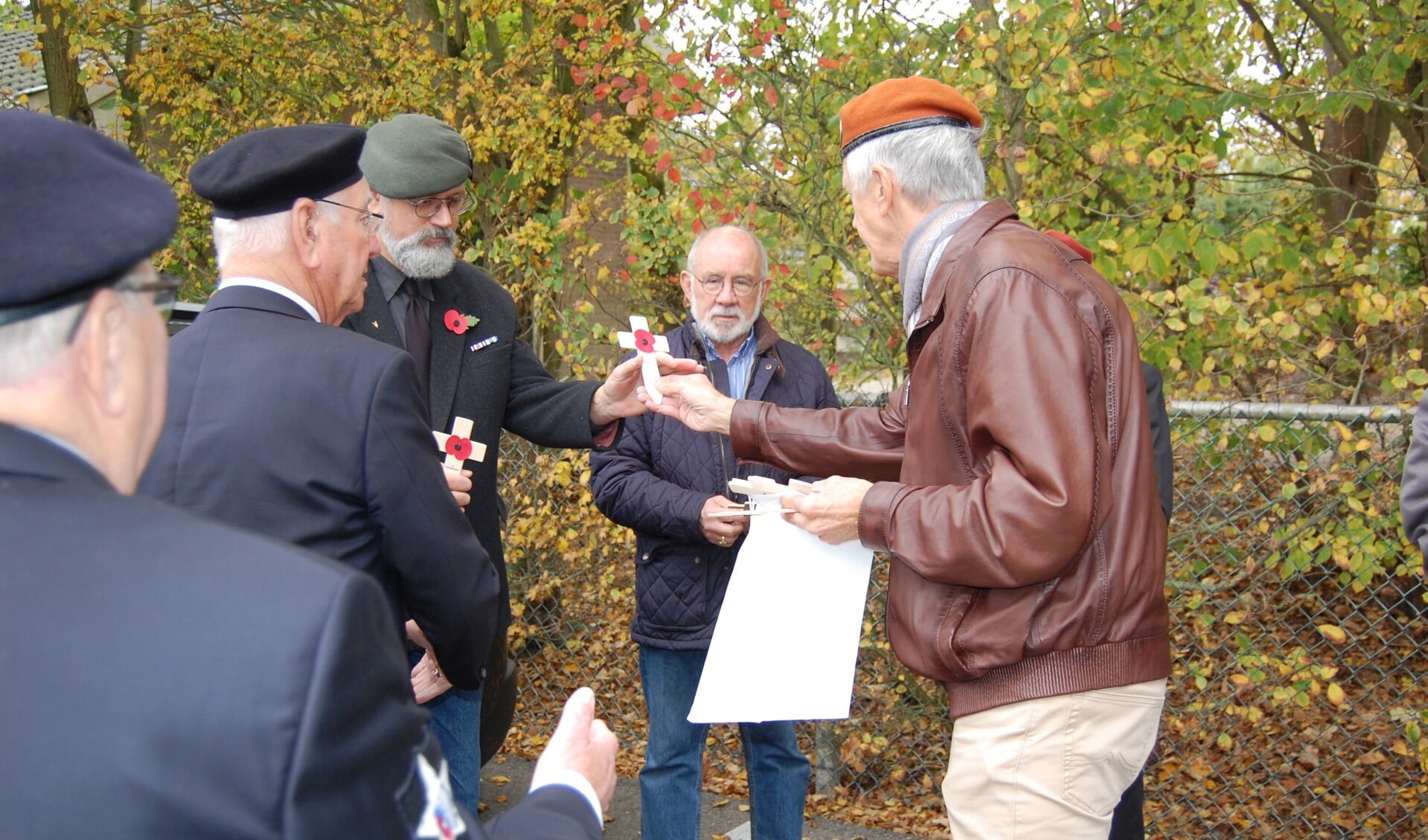 Veteranen plaatsen zondag 26 oktober kleine witte kruisen met klaprozen op de graven van geallieerde vliegers op begraafplaats 'Zandburen'. (Foto: aangeleverd)
