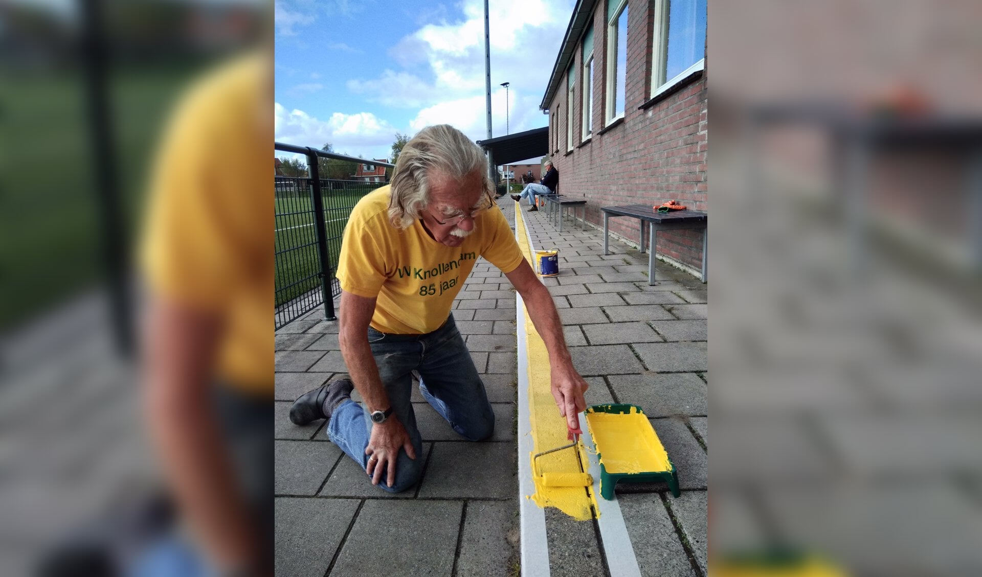 Erelid Jaap Leegwater bezig met het schilderen van een gele lijn bij vv Knollendam. (Foto: Bart van der Laan) 