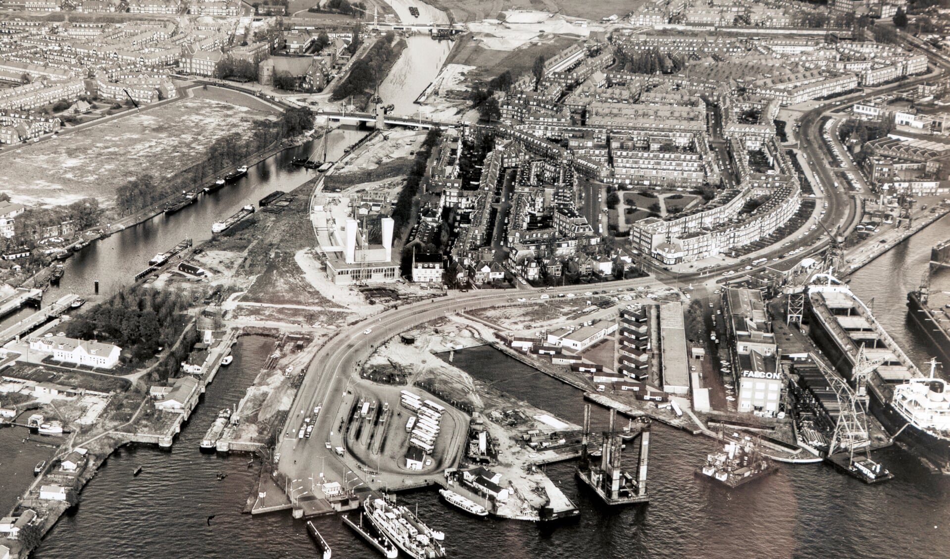Luchtfoto van aanleg Noordelijke ingang IJ-tunnel 1966. Op de voorgrond: waar nu het IJplein is van links naar rechts Busstation NZH, zinklsleuf tunnel, Valkenweg en de ADM. Daarachter de Meeuwenlaan en de Vogelbuurt. (Foto:, Stadsarchief Amsterdam)
