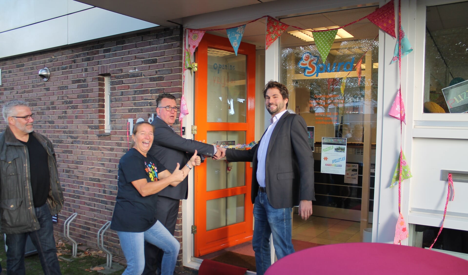 Gerdien van Delden (tweede van links) kijkt tevreden toe hoe Thijs Kroese en Mario Hegger de winkel openen. (Foto: RM/Michael Brouwers)