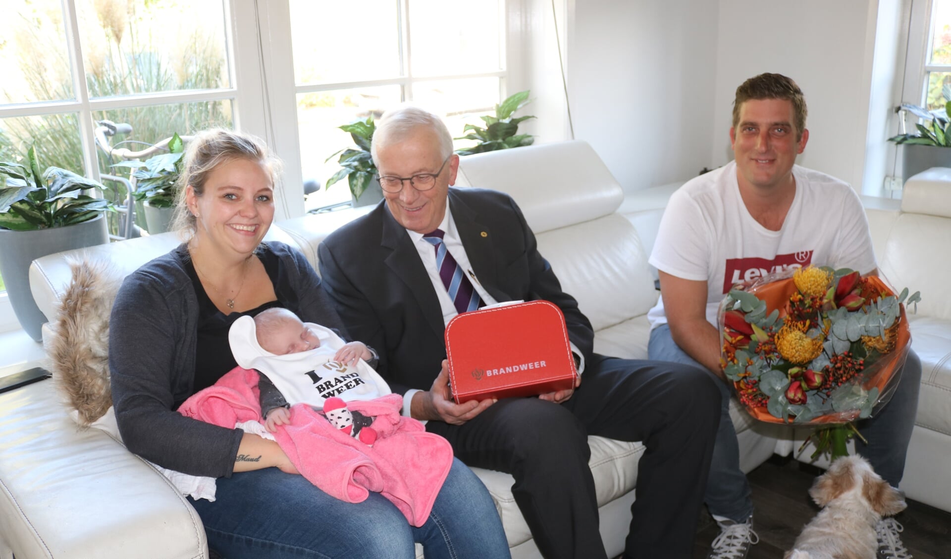 Burgemeester Nijpels overhandigt aan de ouders van Tess Groot het brandweer-geboortekoffertje. (Foto: gemeente Opmeer)