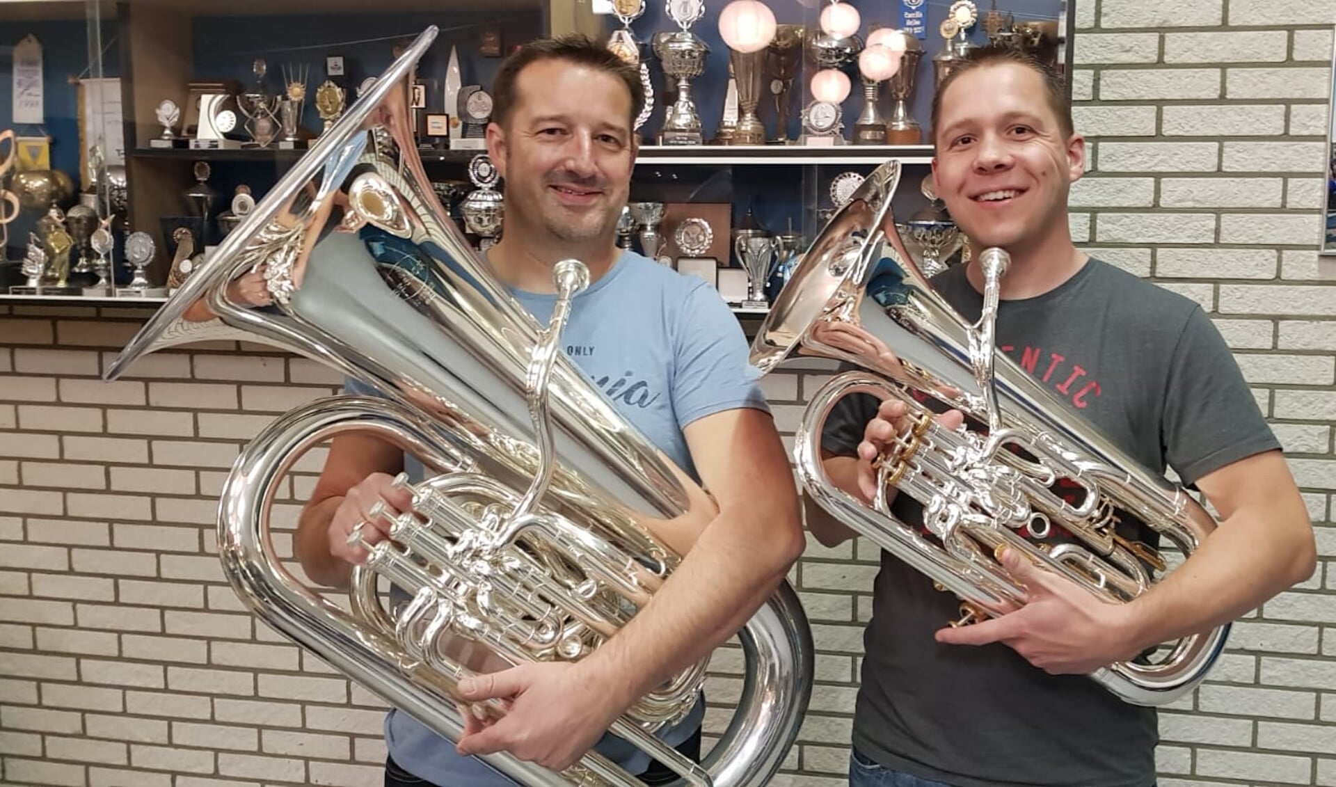 Links Ruben Hottentot (es-bas) en rechts André Vleeshakker (euphonium) met de nieuwe instrumenten. (Foto: aangeleverd) 