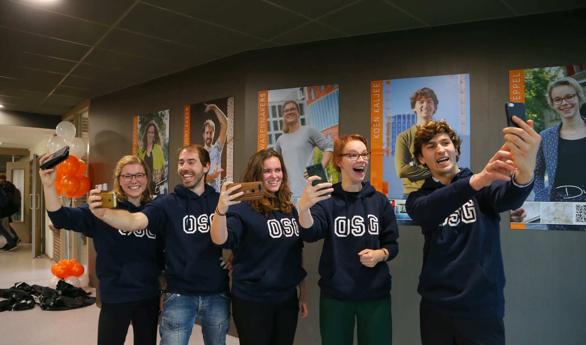 De vijf oud-leerlingen poseren voor een super-selfie bij hun fotogalerij: Margot Wagenmakers, Jort Faber, Eva Schrama, Dieuwertje Toereppel en Koen Kaljee. (Foto: aangeleverd)