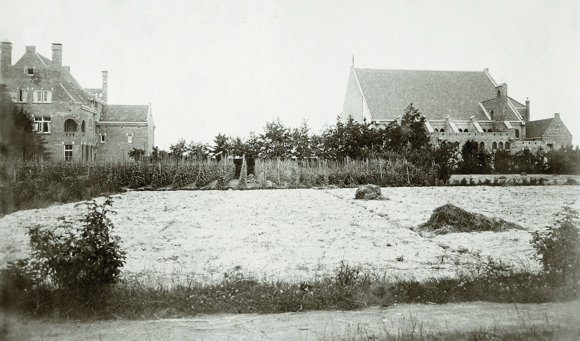 Tussen de kerk (rechts) en de pastorie (links) gaapte in 1915 een flink gat, dat pas later werd opgevuld met een patronaatszaal en de entreepartij met toren (1927).  (FOTO: AANGELEVERD)