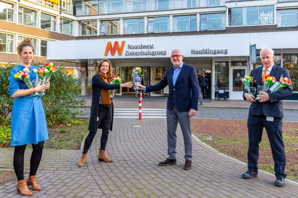 Ger Welbers en Miranda Tonkes van VVV Alkmaar/AlkmaarMarketing overhandigen de tulpen aan Martje de Greeuw en Patrick Balvers van NWZ.