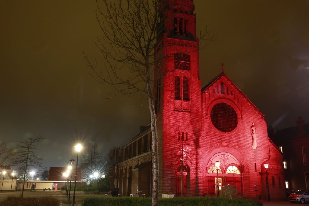 Heilig Hart-kerk baadt in rood licht.