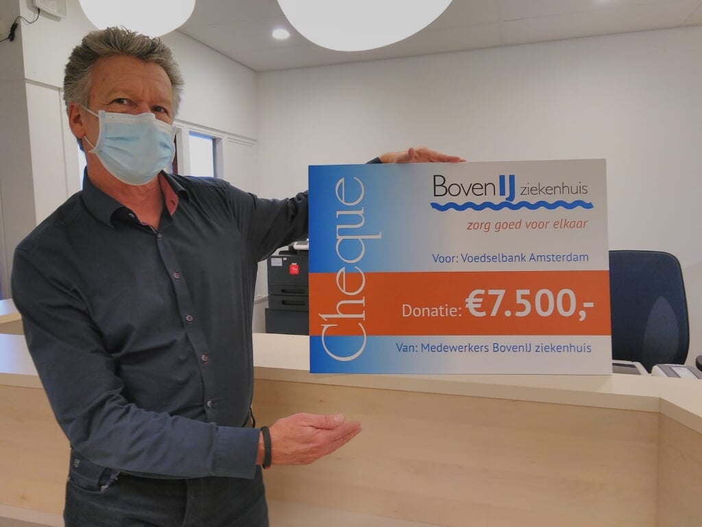 Edwin van der Meer, Raad van Bestuur van het BovenIJ, met de cheque voor de Voedselbank Amsterdam.