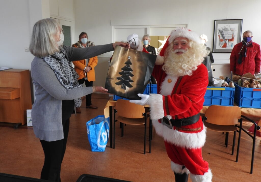 Kerstman Hein Poel overhandigt OVC Kerstpakketten bij Voedselbank.