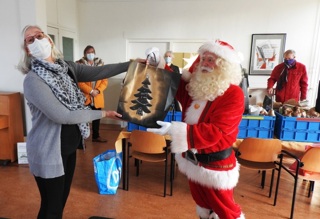 Ook hier de Kerstman Hein en Leo van Schoonhoven vrolijk bij overhandigen pakketten bij de Voedselbank.
