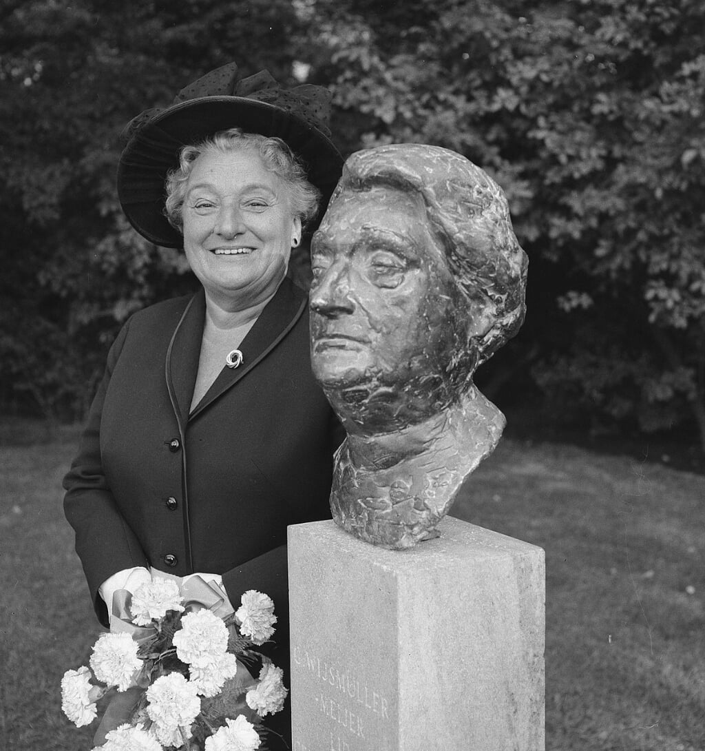 Truus Wijsmuller bij haar borstbeeld in Amsterdam.