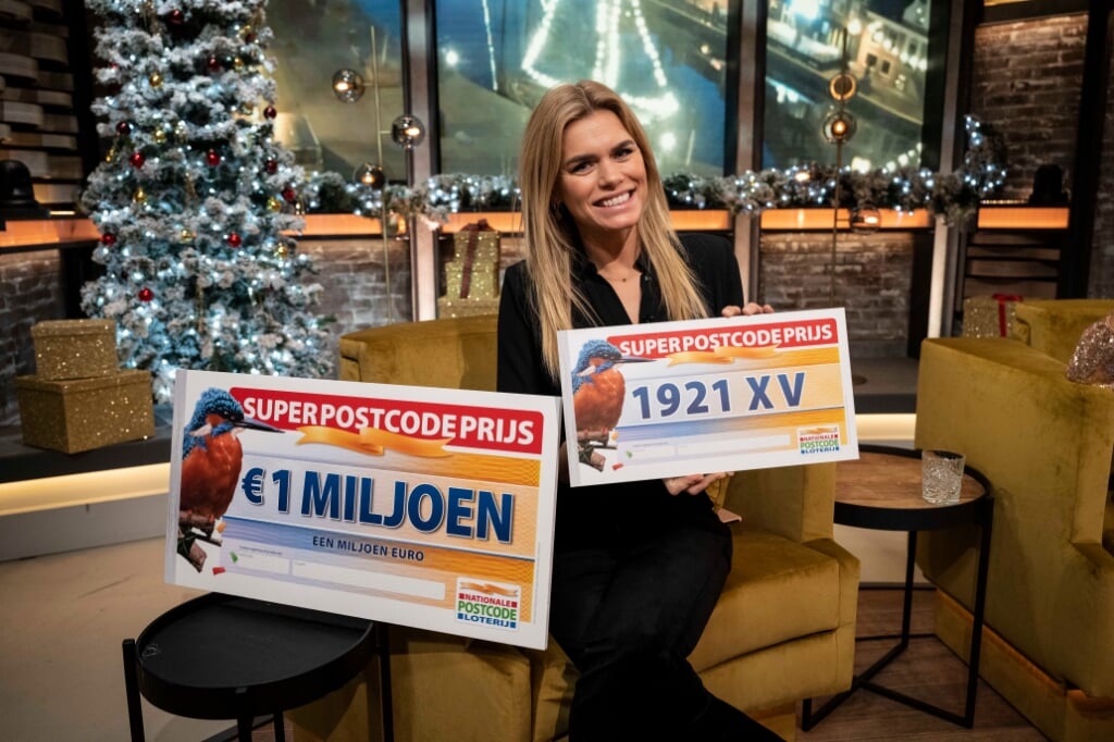 Nicolette van Dam toont de winnende postcode van de Super Postcodeprijs van de Postcode Loterij.