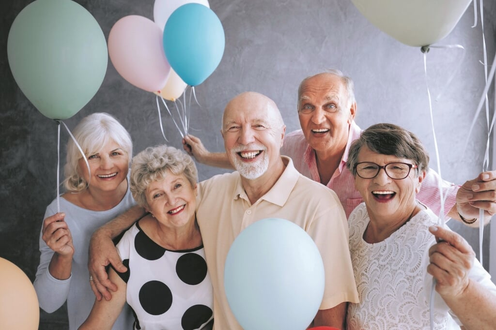 Senioren vieren een feestje. De wens van een papieren versie van de coronapaspoort is ingewilligd.