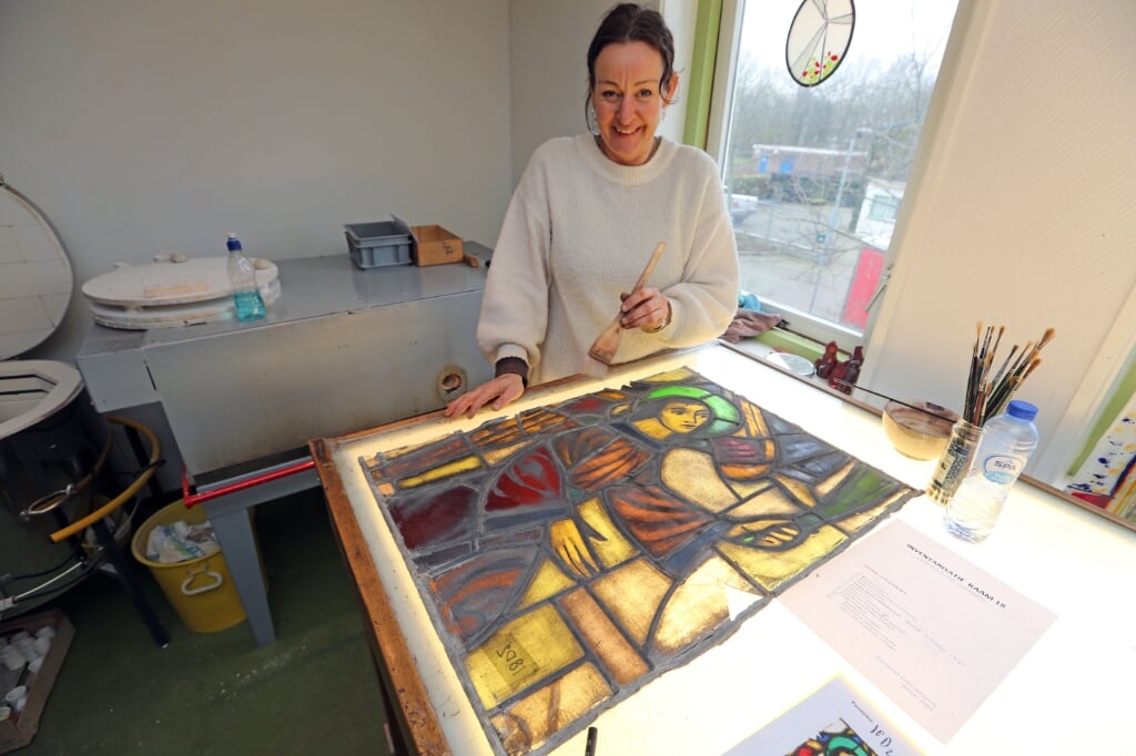 Marije Wolfswinkel restaureert glas-in-loodramen in haar glasatelier.