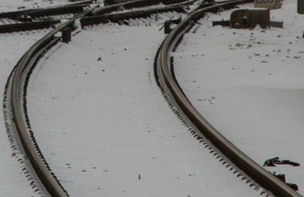 Een spoorlijn in de sneeuw.