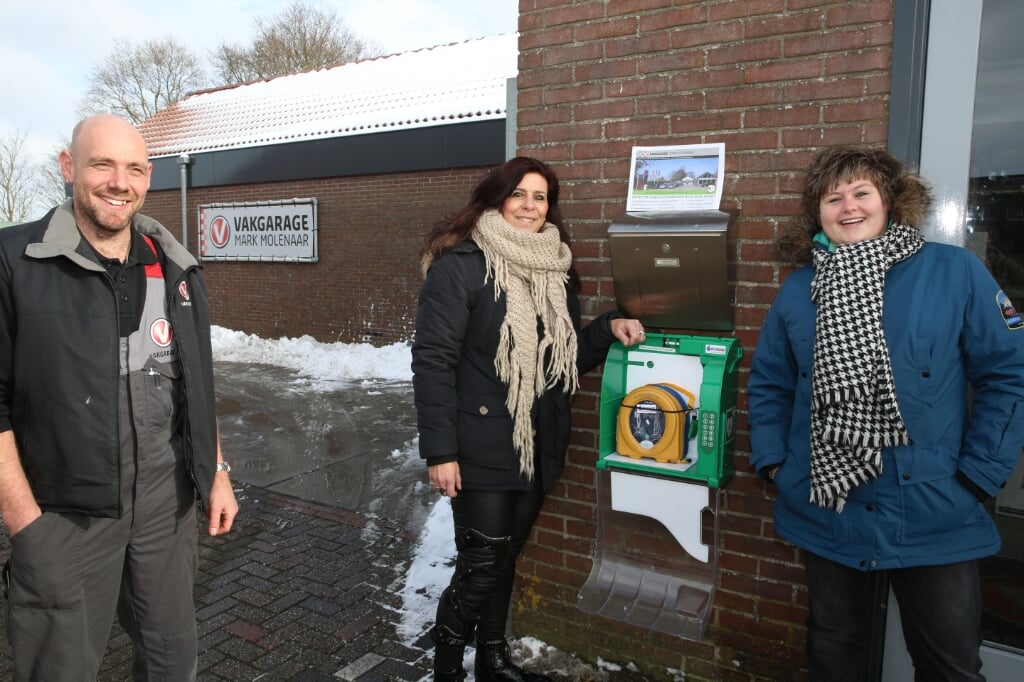 Harry hangt de AED op met Jacqueline Hink-Haarms, voorzitter van EHBO Sint Pancras en Harry. 
