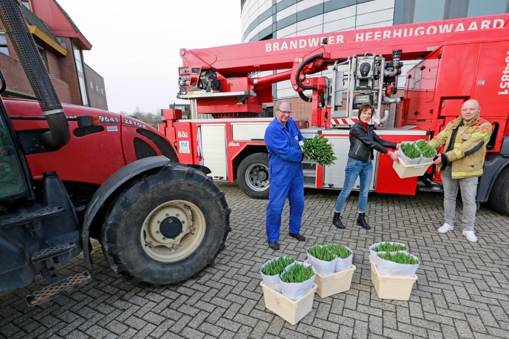 De plaatselijke brandweer kreeg uit handen van Marco Kroon (in blauwe overall) en Helma Vermuë van LTO-Noord bossen tulpen uitgereikt.