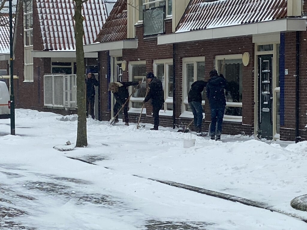 Jongeren in Enkhuizen schuiven afgelopen zondag sneeuw.