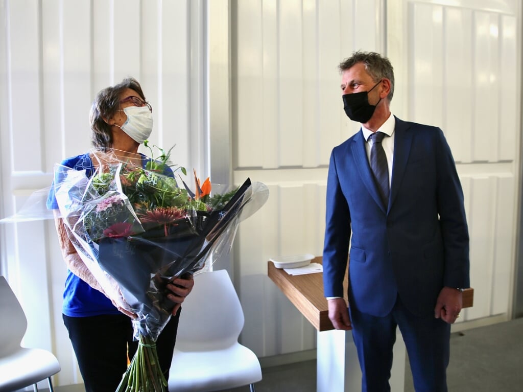 Burgemeester Smit met de eerste gevaccineerde persoon die in de bloemetjes wordt gezet. 