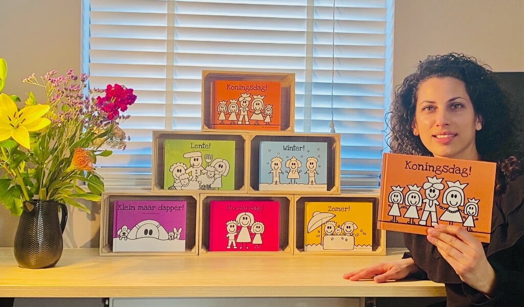 Schrijfster Alisa Uriakhel-Bleijerveld toont een deel van haar collectie uitgegeven kinderboeken.
