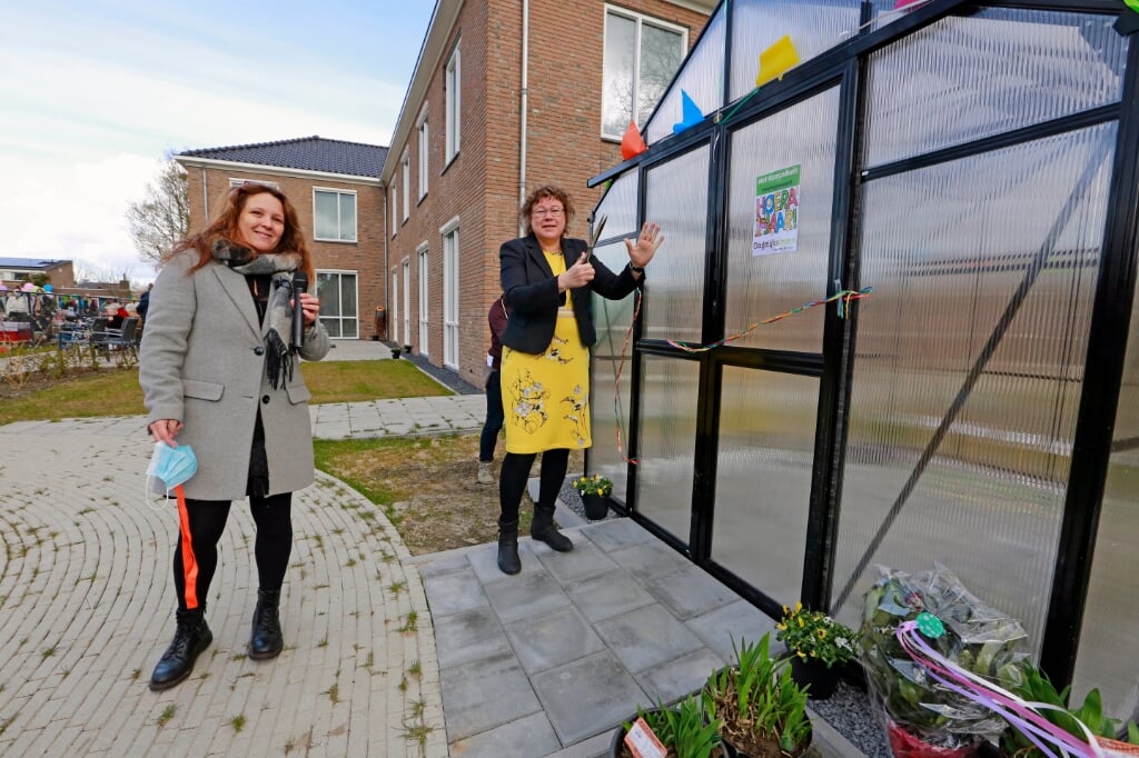 Wethouder Annette Groot verricht de officiële openingshandeling van de tuinkas; links locatiemanager van het Icarushuis Linda Hulscher.