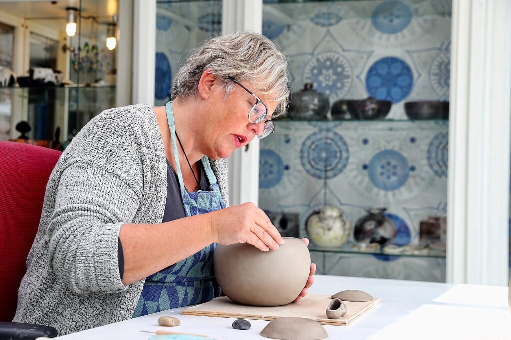 Keramiste Gerdien Noordeloos in haar atelier waar zij werkt aan een urn.