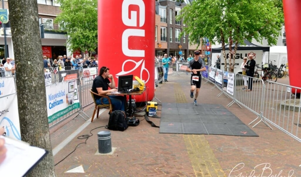 Deelnemer komt over de finish bij een eerdere editie van de triatlon in Castricum.