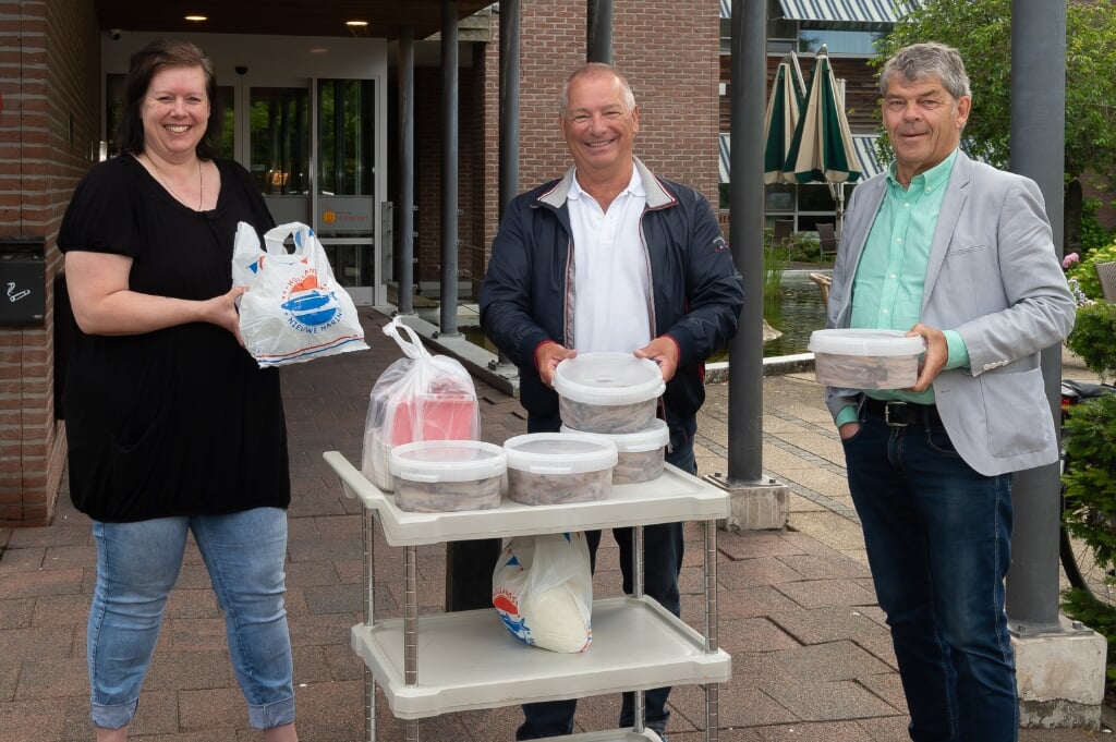 Activiteitenbegeleidster Lisette Muts van Novawhere neemt de tonnetjes haring in ontvangst van Frits Dix (midden) en  Co Boots van Vrienden voor Purmerend. 