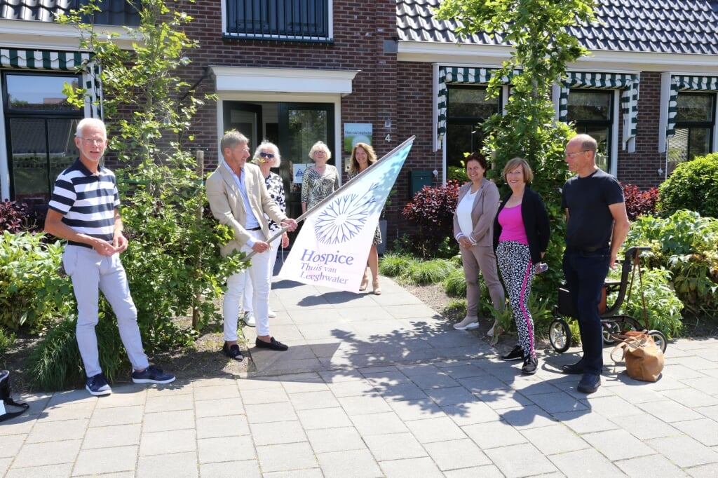 In aanwezigheid van bestuursleden Cees Verkade (l) en Klaas Kwadijk (r), de coördinatoren en de communicatiegroep, bevestigen bestuursvoorzitters Kees Sietsema en Corrie Jaarsma de nieuwe vlag.