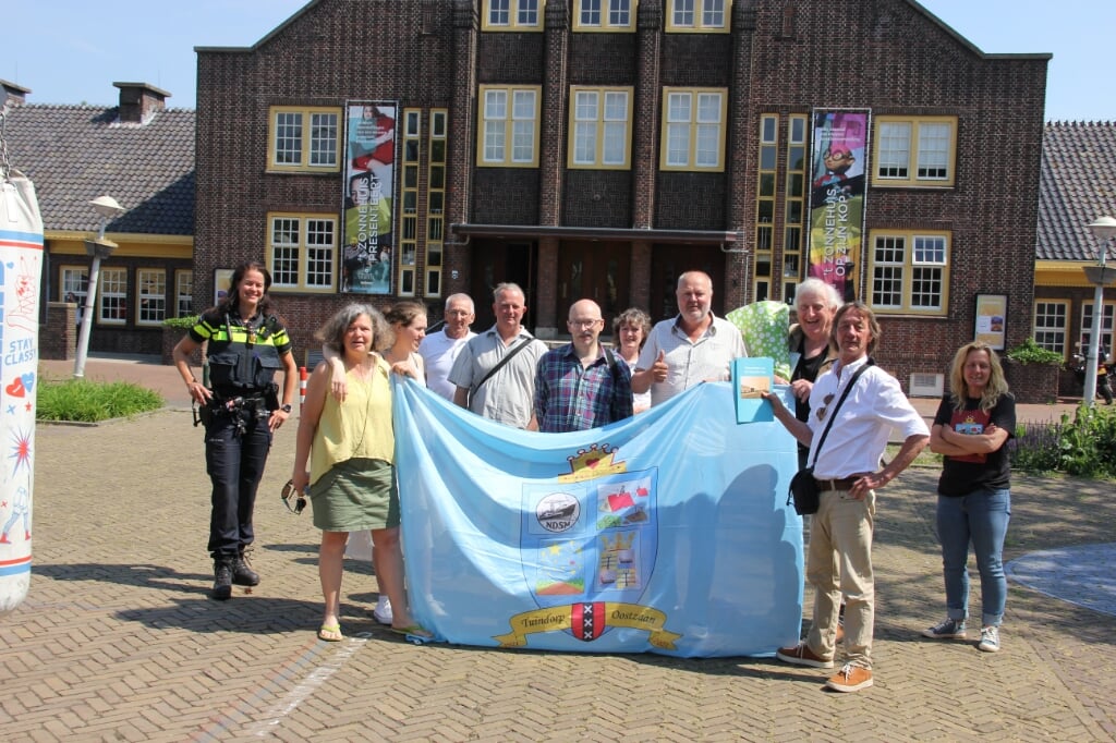 Leden van de HATO en genodigden tijdens de uitreiking van het boek met de vlag van Tuindorp Oostzaan 100 jaar.