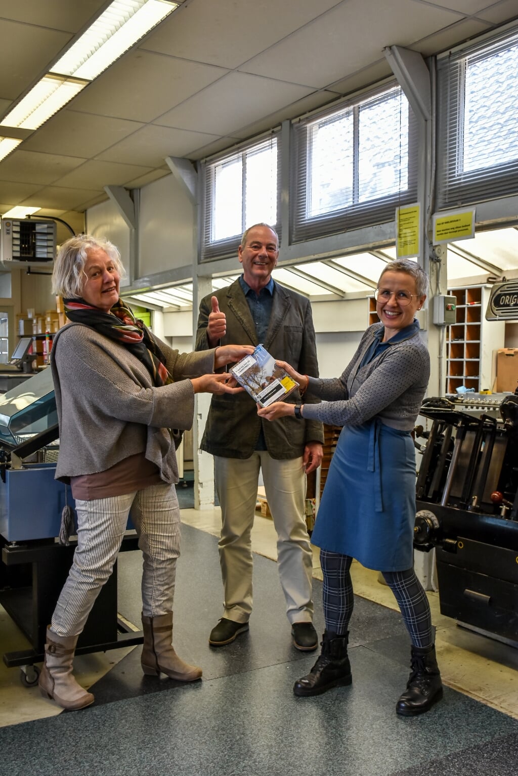Emilieke Nederlof (Humanitas), Nico van Braam (voorzitter Zaanse Uitdaging) en Marjolein Lensink van de drukkerij.