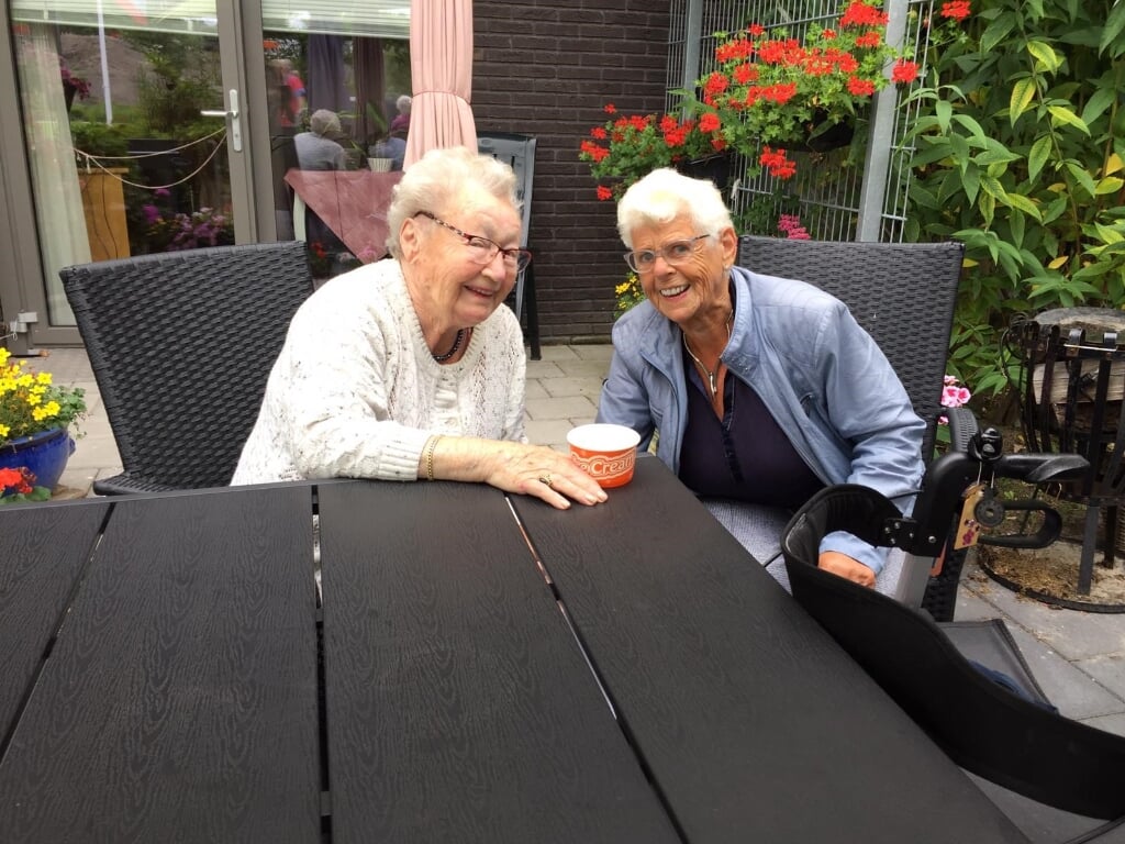 Twee bewoonsters van woonzorgcentrum Hugo-Waard genieten samen van een ijsje van Gouden Dagen Heerhugowaard.