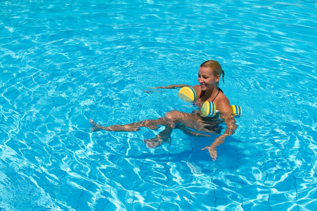 Aqua aerobic, woman in water with dumbbells