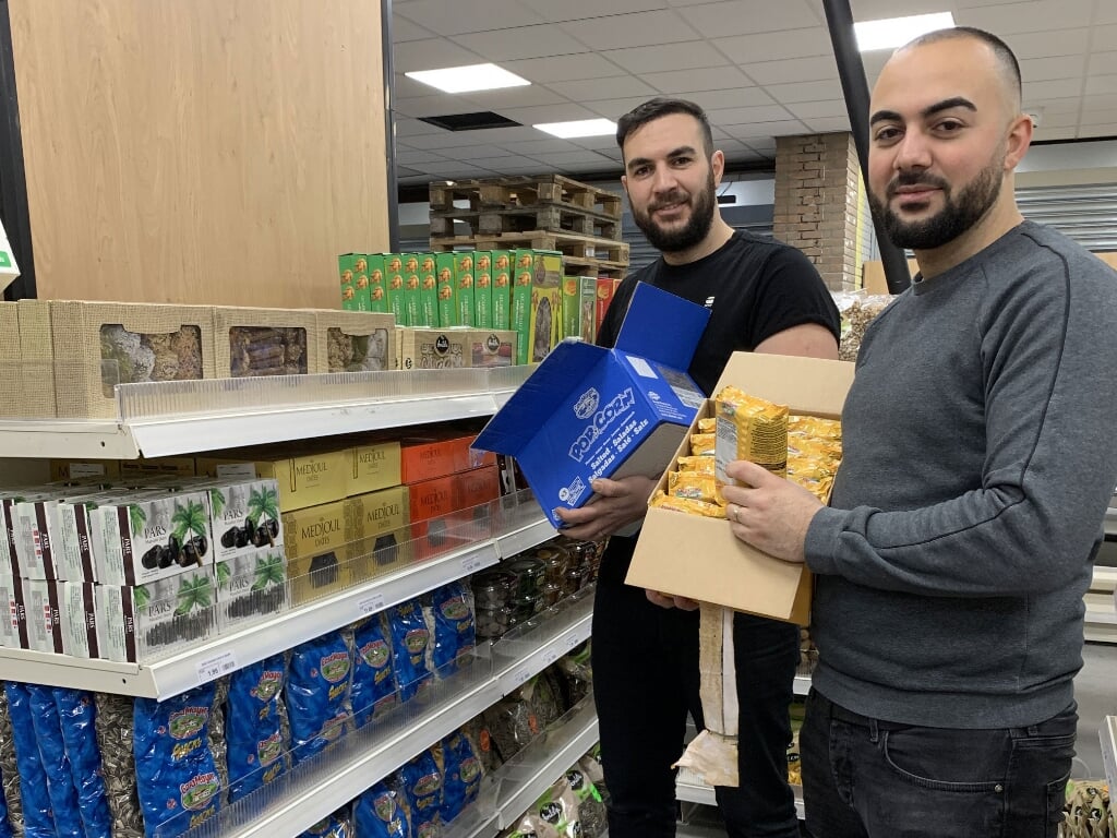 Oktay en Guvenc Aydogdu leggen de laatste hand aan de herinrichting van de supermarkt.